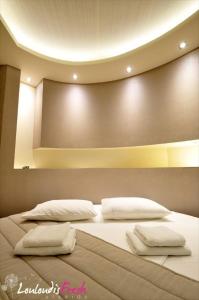 a bedroom with a bed with two pillows on it at Louloudis Fresh-Adults Only in Skala Rachoniou
