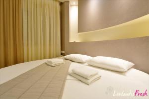 a bed with two white pillows on top of it at Louloudis Fresh-Adults Only in Skala Rachoniou