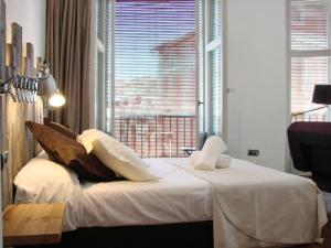 a bedroom with a bed with a large window at Las Coles Apartasuites in X&agrave;tiva