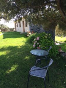 une table et une chaise assises dans l'herbe dans l'établissement Samothraki Suites Kalisti, à Xiropótamos