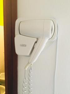 a white hairdryer hanging on a wall at Hotel Bellevue in Cesenatico