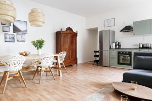 a living room with a table and chairs and a kitchen at Be in Berlin Apartments in Prenzlauer Berg in Berlin