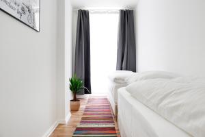 a bedroom with two beds and a potted plant at Be in Berlin Apartments in Prenzlauer Berg in Berlin