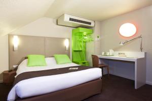 Cette chambre comprend un lit, un bureau et une étagère verte. dans l'établissement Campanile Dunkerque Sud - Loon Plage, à Loon-Plage