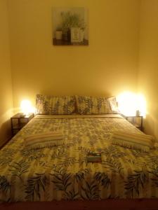 a bed in a bedroom with two lamps on both sides at Rooms 4 you - Small Yellow room in Portimão