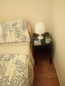 a bedroom with a bed and a night stand with a lamp at Rooms 4 you - Small Yellow room in Portimão
