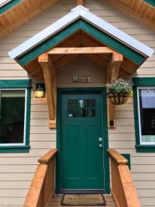 Una puerta de entrada de una casa con una puerta verde. en Talkeetna Mount Dall Cottage with WiFi&laundry, en Talkeetna
