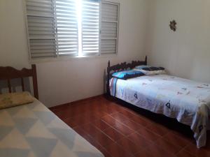 a bedroom with two twin beds and a window at Apartamento do Sr Luiz e dona cida in Lambari