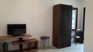 uma sala de estar com uma televisão e uma mesa com um banco em Calape Forest Resort em Calape
