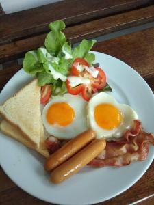 a plate of food with eggs and sausage and a salad at Anyamanee Resort in Cha Am