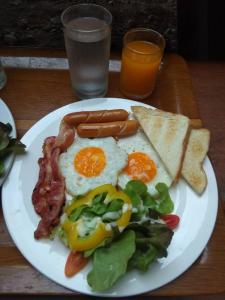 um prato de pequeno-almoço com ovos, bacon e torradas em Anyamanee Resort em Cha Am