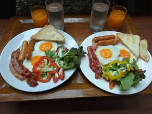 2 talerze jedzenia śniadaniowego z jajkami, bekonem i sałatką w obiekcie Anyamanee Resort w mieście Cha Am