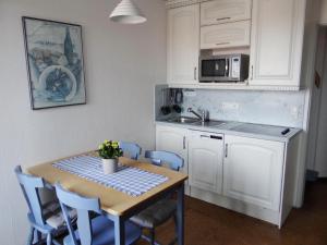 een keuken met een tafel en stoelen en een magnetron bij 50097... in Carolinensiel