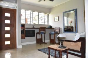 a living room with a table and a mirror at 2 Karachi Too in Kingston