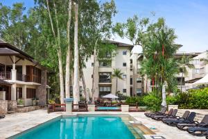 una piscina con tumbonas frente a un edificio en Temple 312 Newly Refurbished Spacious Studio Resort Spa Apartment - UNDER NEW MANAGEMENT en Palm Cove