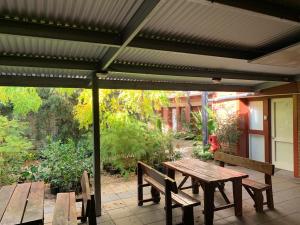 einen Holztisch und Bänke auf einer Terrasse in der Unterkunft CROWN CENTRAL BUSINESS DISTRICT MOTEL - NO UNDER 18s in Bendigo