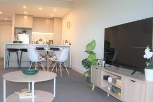 a living room with a large flat screen tv at Stunning Views Sydney Olympic Park in Sydney