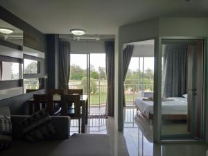 a bedroom with a bed and a dining room with a balcony at Grandbeach2 B52 By malai in Mae Pim +61 photos