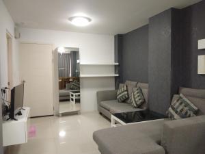 ein Wohnzimmer mit einem Sofa und einem TV in der Unterkunft Grandbeach2 B52 By malai in Mae Pim