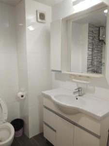 ein weißes Bad mit einem Waschbecken und einem WC in der Unterkunft Grandbeach2 B52 By malai in Mae Pim