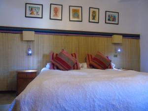 a bedroom with a large white bed with pillows at Hotel Pat'ta Hoiri in San Pedro de Atacama
