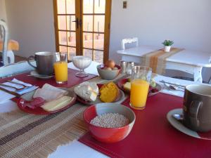 a table with breakfast foods and orange juice on it at Hotel Pat'ta Hoiri in San Pedro de Atacama