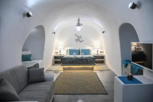 a living room with a bed and a couch at Serenity Blue (Cave house) in Akrotiri