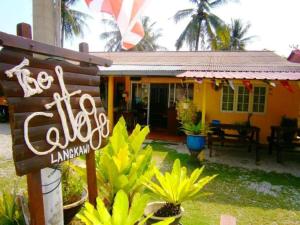 ein kleines gelbes Haus mit einem Schild davor in der Unterkunft THE COTTAGE LANGKAWI in Pantai Cenang