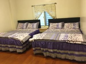 due letti uno accanto all'altro in una camera da letto di Hong Guo Homestay a Ruisui