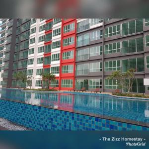 a swimming pool in front of a large building at The Zizz Homestay@Damansara Damai in Petaling Jaya