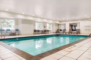 una piscina en un hotel con sillas y mesas en Sleep Inn & Suites Columbus, en Columbus