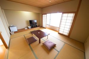 vistas panorámicas a una sala de estar con mesa y sillas en Sea Aiga Kaigetsu, en Sumoto