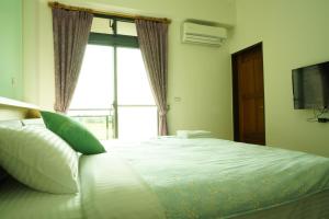 a bedroom with a large bed with a window at TiAmo B&B Yilan in Dayin