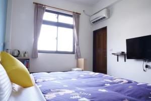 a bedroom with a bed and a window and a television at TiAmo B&B Yilan in Dayin