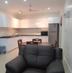a living room with a couch and a table in a kitchen at Prestige Apartments - Solomon Islands in Honiara