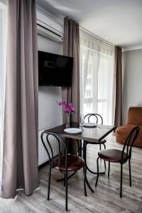 - une table à manger et des chaises dans le salon dans l'établissement Apart Reserve Sloboda Loft, à Ivano-Frankivsk