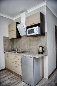 a kitchen with a sink and a microwave at Apart Reserve Sloboda Loft in Ivano-Frankivsʼk