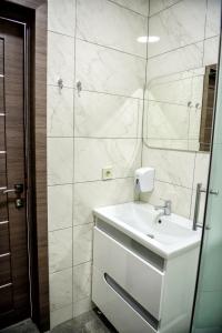 bagno con lavandino bianco e specchio di Apart Reserve Sloboda Loft a Ivano-Frankivsʼk
