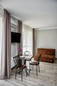 sala de estar con mesa, sillas y sofá en Apart Reserve Sloboda Loft, en Ivano-Frankivsk