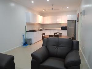 a living room with a couch and a kitchen at Prestige Apartments - Solomon Islands in Honiara