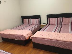 2 Betten in einem Zimmer mit rosa Bettwäsche in der Unterkunft Hong Guo Homestay in Ruisui
