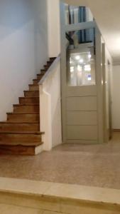 Un pasillo con una puerta y escaleras en un edificio. en Cinghiale Bianco, en Cagliari