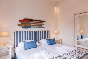 1 dormitorio con 2 camas y espejo en Boufounis Studios, en Kamarai