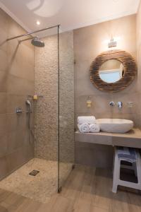 y baño con ducha, lavabo y espejo. en Boufounis Studios, en Kamarai