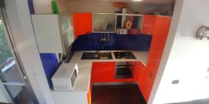 a small kitchen with red and blue cabinets at Appartamento Los Andes in Ortona