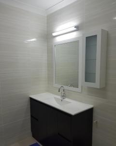 a bathroom with a sink and a mirror at Prestige Apartments - Solomon Islands in Honiara