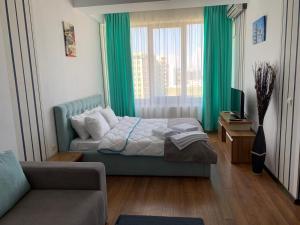 ママイアにあるCazari Mamaia Summerlandのベッドルーム1室(緑色のカーテンとソファ付きのベッド1台付)