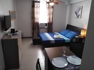 a small room with a bed and a table with glasses at Mak'z Condo Place in Mactan