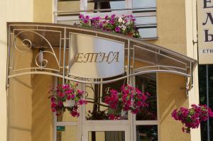 a store front with a sign and flowers on it at Etna Hotel in Lviv