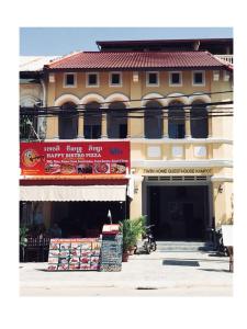 un edificio con una señal roja delante de él en TWIN HOME Guesthouse en Kampot